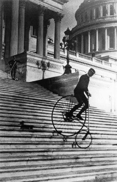 Riding a penny farthing backwards up the grand staircase in the back of the US Capitol building, Washington DC