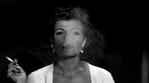 An older Rita Hayworth, smoking, GIF